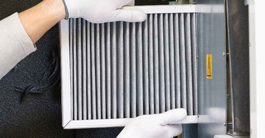 person pulling out air filter from AC