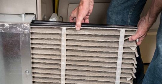 guy checking air filter of an AC unit