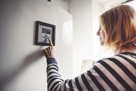 woman using thermostat