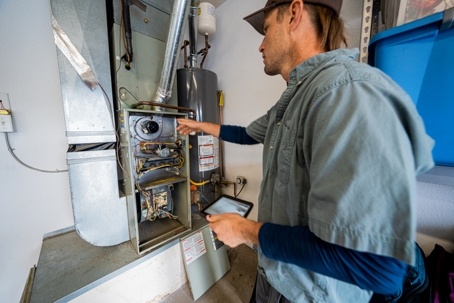 technician inspecting furnace system